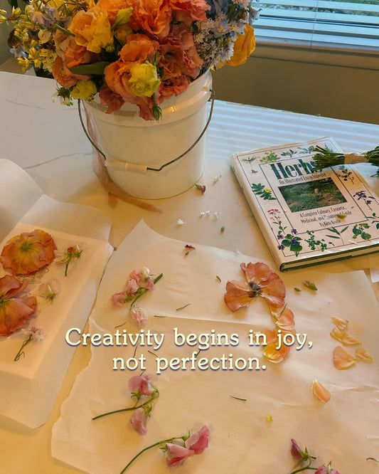 A large bucket of flowers being pressed into wax paper
