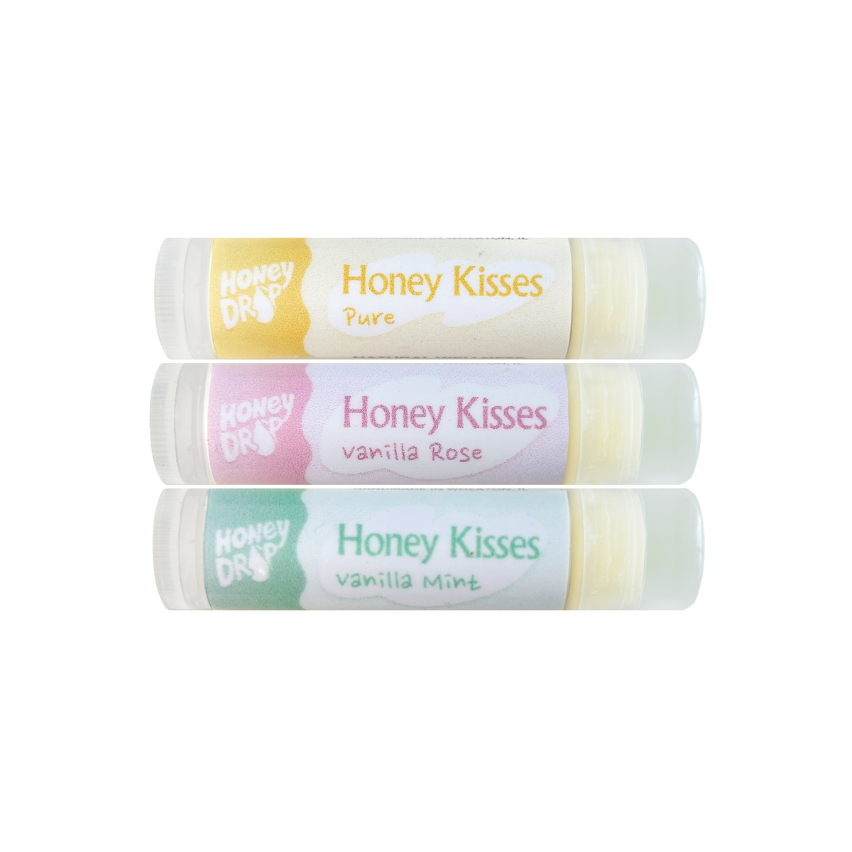 Three Honey Drops Honey Kisses Pure lip balm tubes stacked vertically on a white background, featuring yellow, pink, and green labels with vanilla rose and vanilla mint flavors.