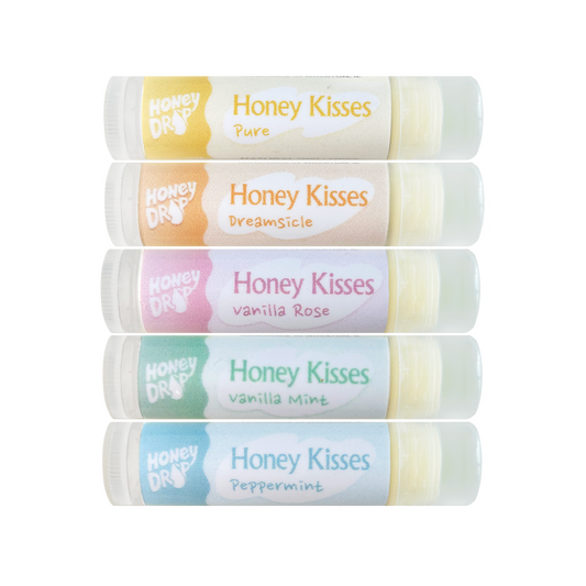 Five Honey Drops Honey Kisses lip balm tubes stacked vertically on a white background, featuring Pure, Dreamsicle, vanilla Rose, vanilla Mint, and Peppermint flavors.