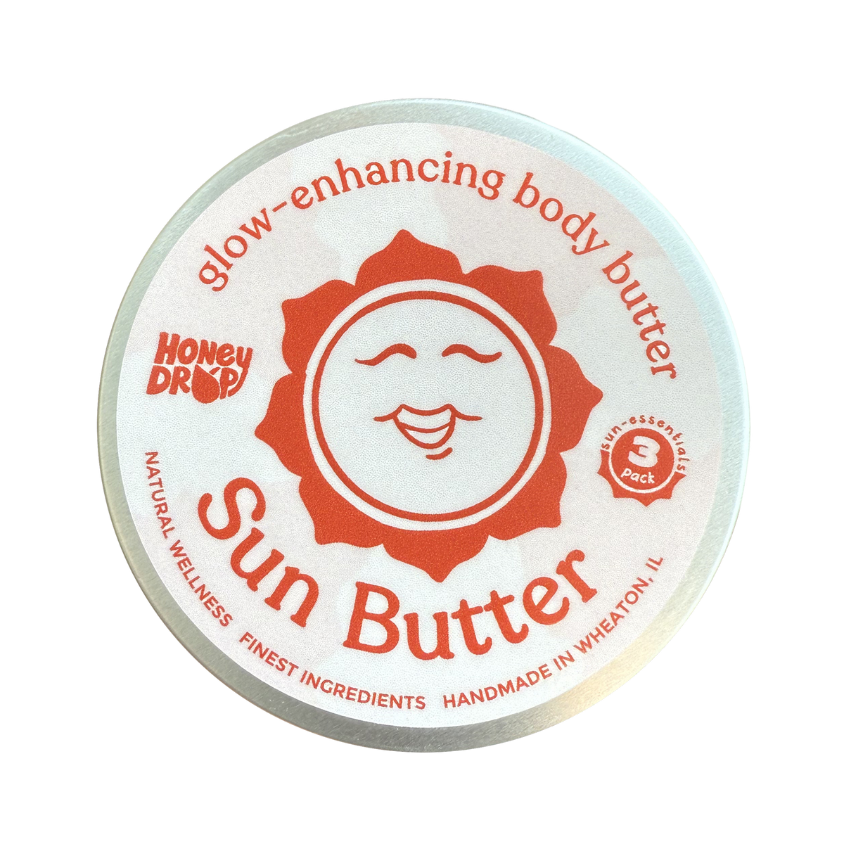 A round metal tin of HoneyDrop Sun Butter body butter, featuring a white lid with a prominent orange sun graphic and red text, isolated on a white background.